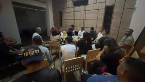 Members of the response effort meet around a table at night