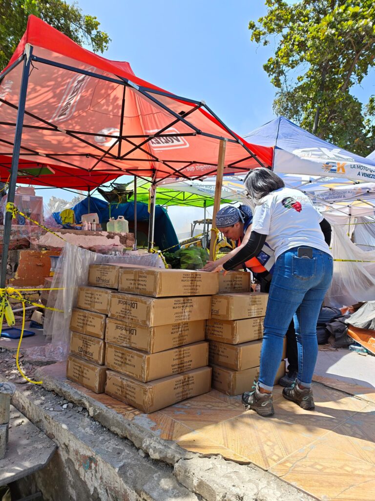 Volunteers unload cartons from the emergency shipment at a field response site