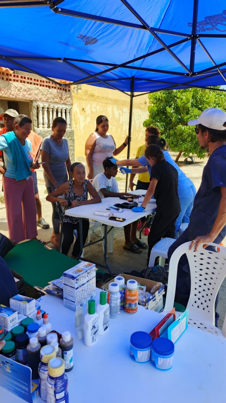 Health professionals and residents at a table with medical supplies.