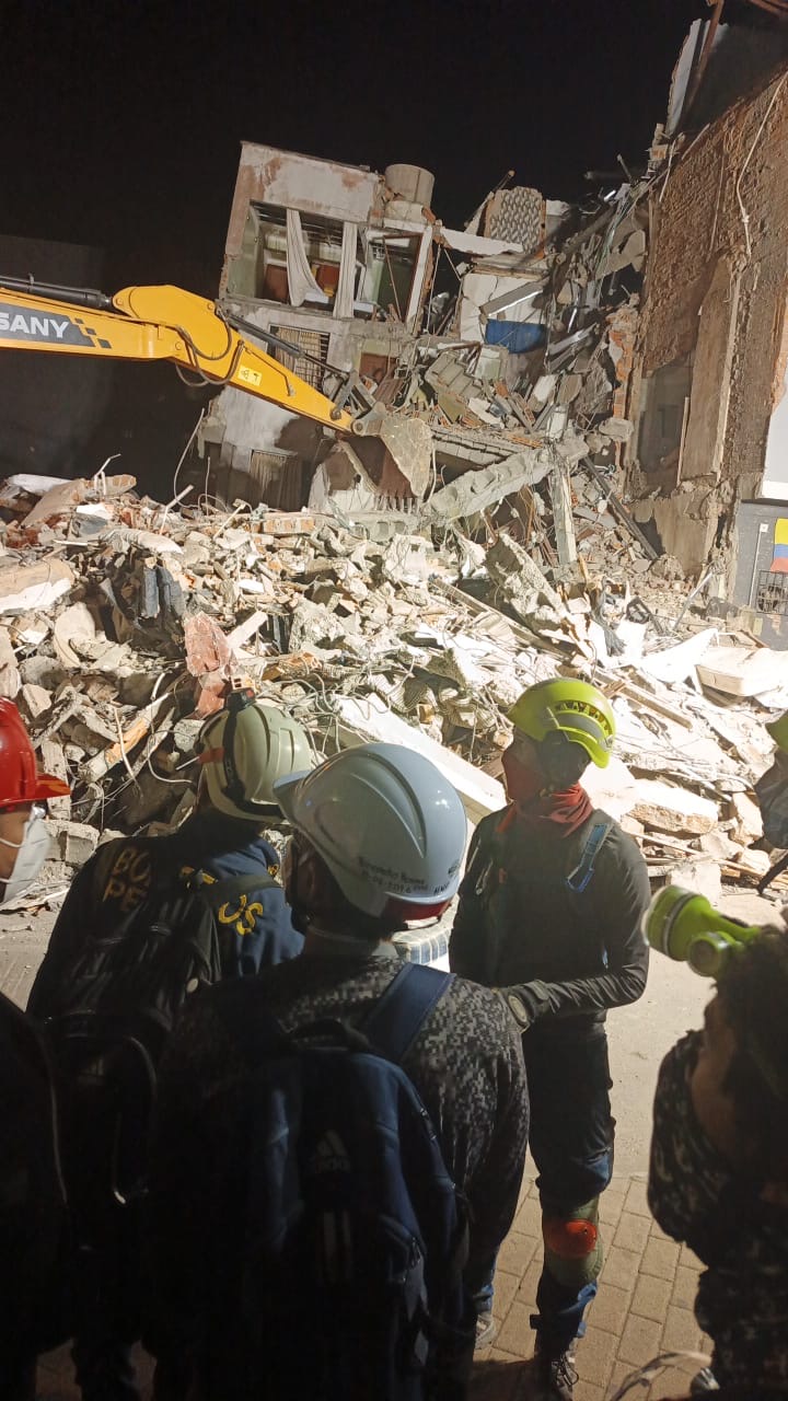 Responders work by rubble after dark