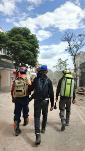 Rescue workers walk between locations carrying equipment
