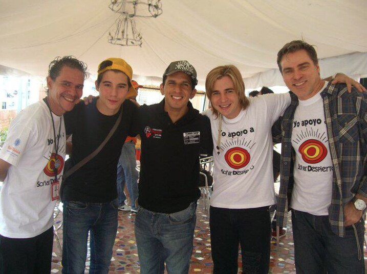 Román EL RO standing with guests wearing shirts supporting Fundación Soñar Despierto.