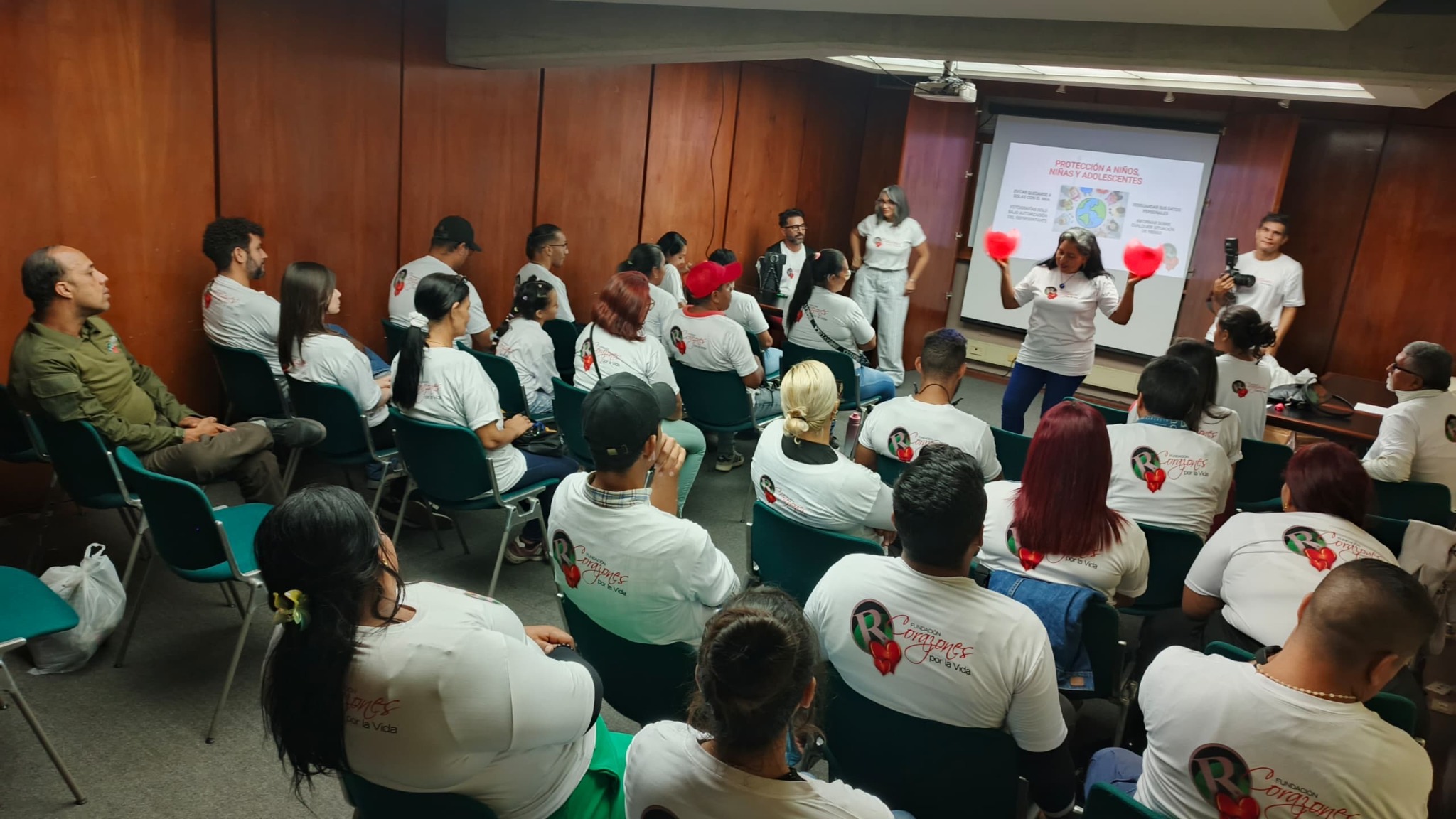 A social-work facilitator addresses volunteers during a dignity-first care workshop.