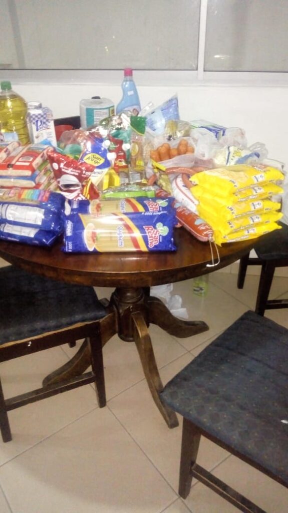Table filled with food and household supplies delivered to a family during the COVID-19 pandemic.
