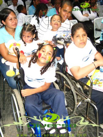 Children and adults, including wheelchair users, at the community gathering.