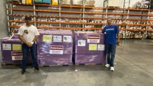 Representatives of Americares and Fundación Corazones por la Vida with five emergency response pallets