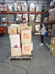 Warehouse shelves and volunteers handling boxes in March 2019.