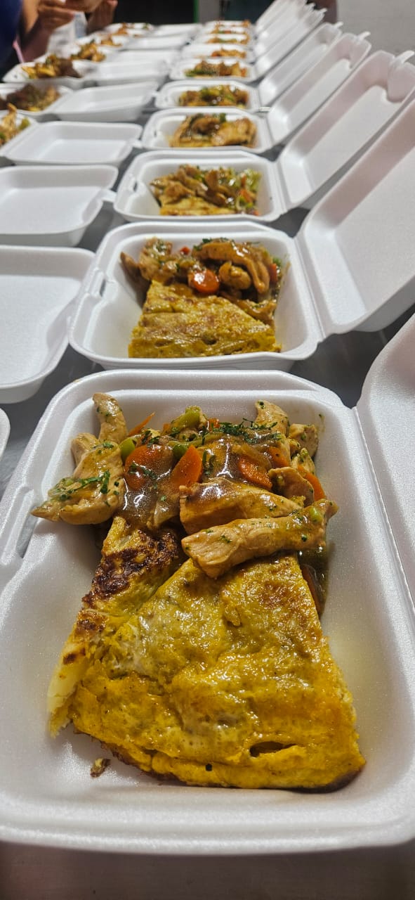 Rows of freshly prepared hot meals packaged for distribution in La Guaira.