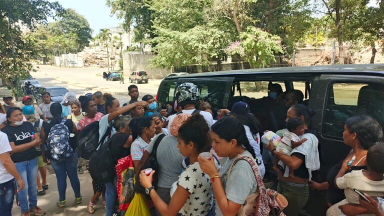 Residents receiving humanitarian assistance beside a foundation distribution vehicle in La Guaira.