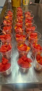 Prepared cups of fresh fruit for community food distribution.