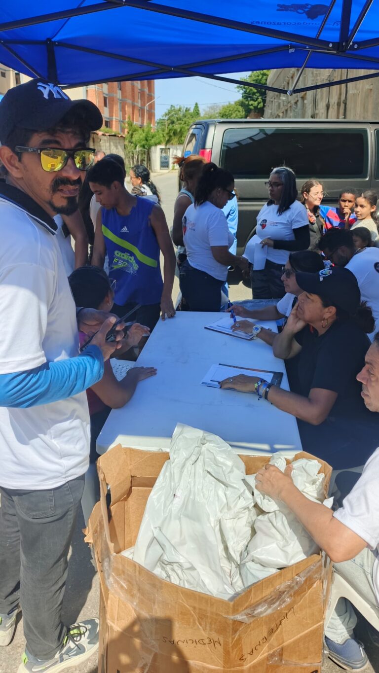 Bags of family supplies beside a registration table at Campamento Solidaridad.