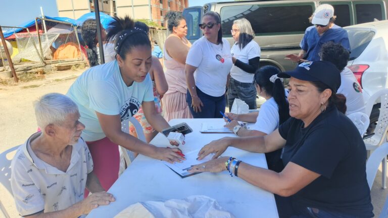 Foundation volunteers listen to residents and review information at a table.