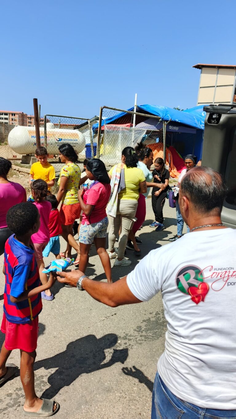 Foundation team member handing supplies to a resident at Campamento Solidaridad.