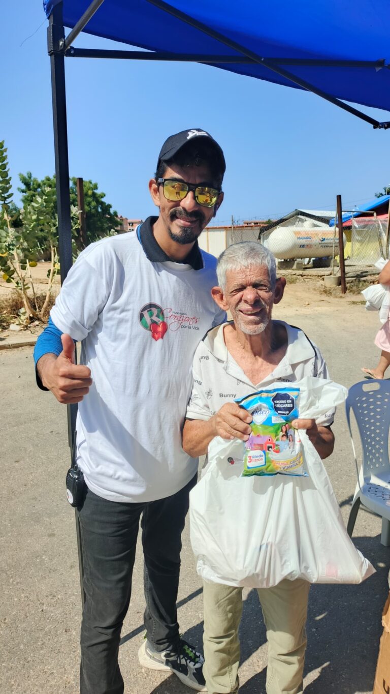 Resident holding a bag of supplies with a foundation volunteer.