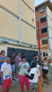 Foundation representative talking with residents outside a building.