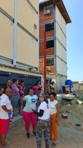 Residents and foundation volunteers in conversation outside a building.